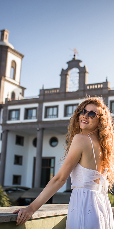  Iconic image of a woman in front of the facade of the Lopesan Villa del Conde, Resort & Thalasso hotel in Meloneras, Gran Canaria 
